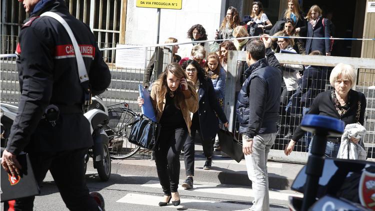 People flee from the Milan courthouse.