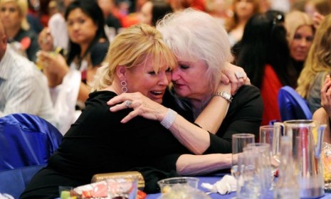 Romney supporters comfort each other after hearing that President Obama won a second term.