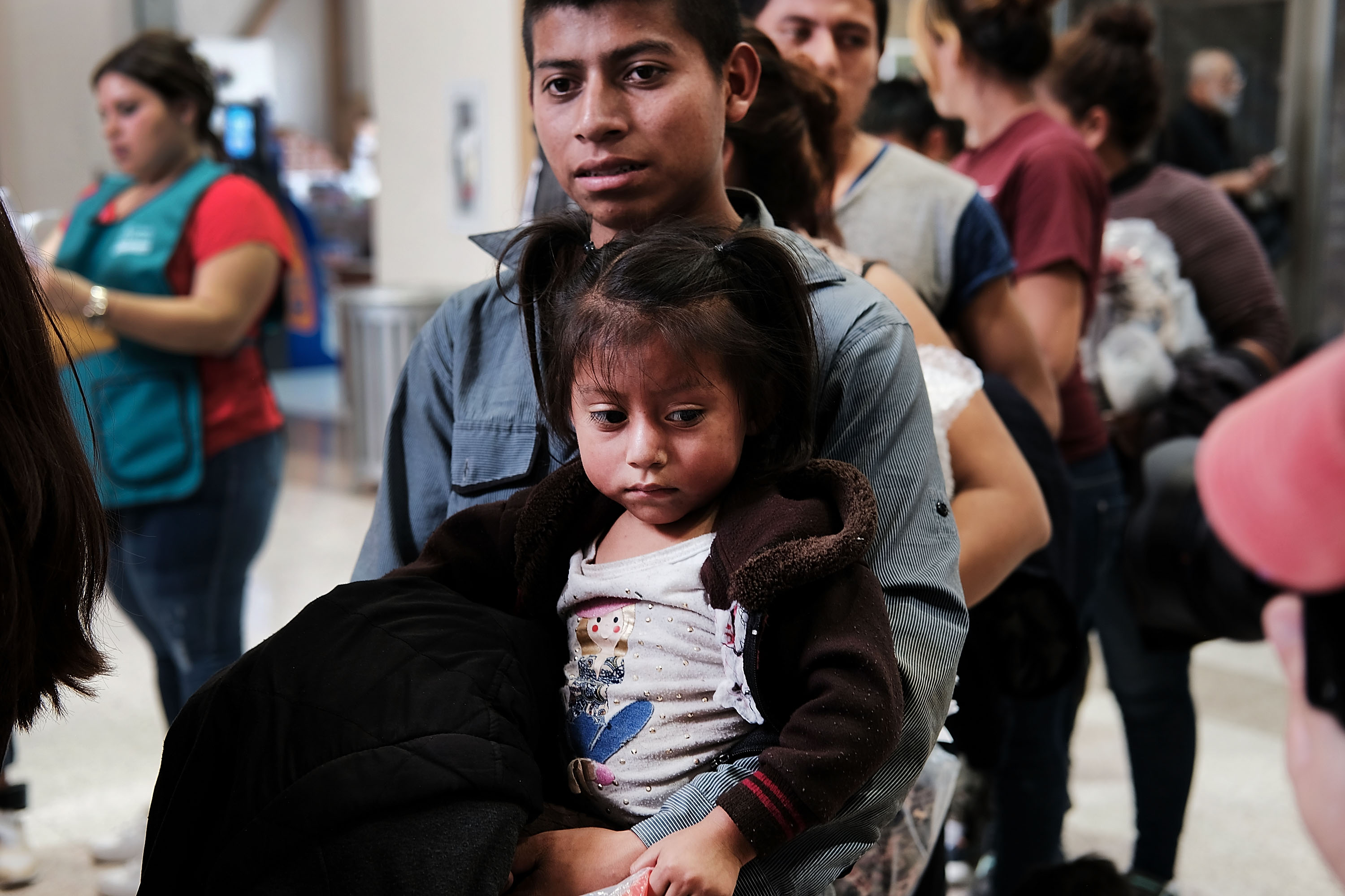 Dozens of women, men and their children, many fleeing poverty and violence in Honduras, Guatamala and El Salvador, arrive at a bus station following release from Customs and Border Protection