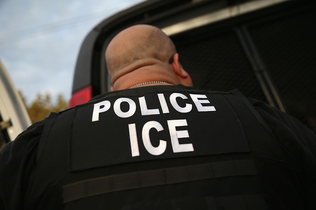 ICE agents detain an immigrant.