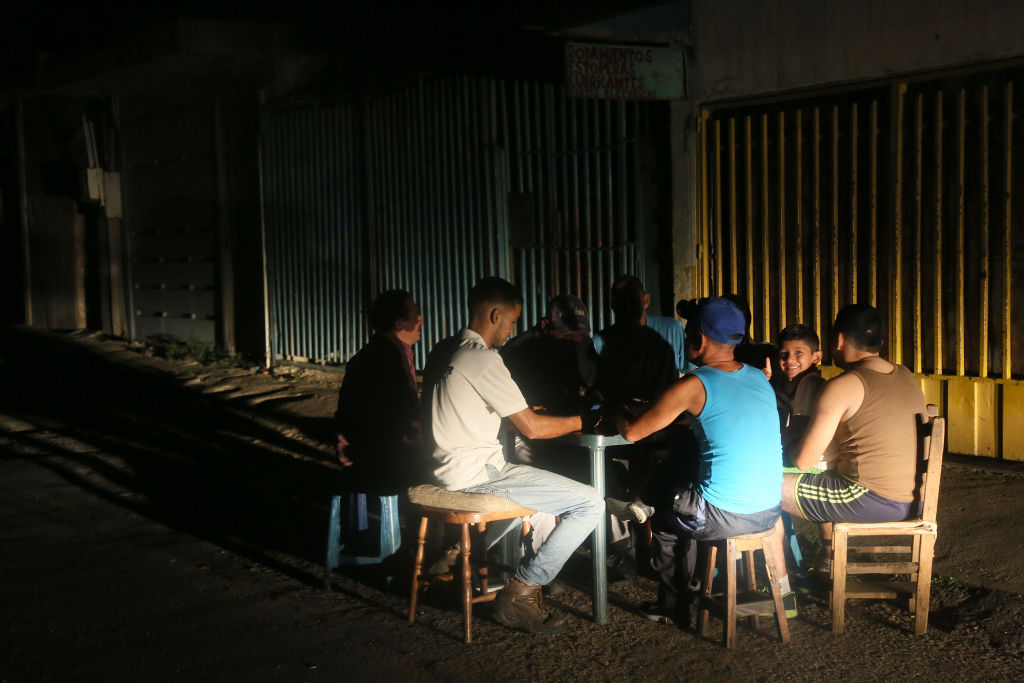 People sit outside during a blackout in Venezuela.