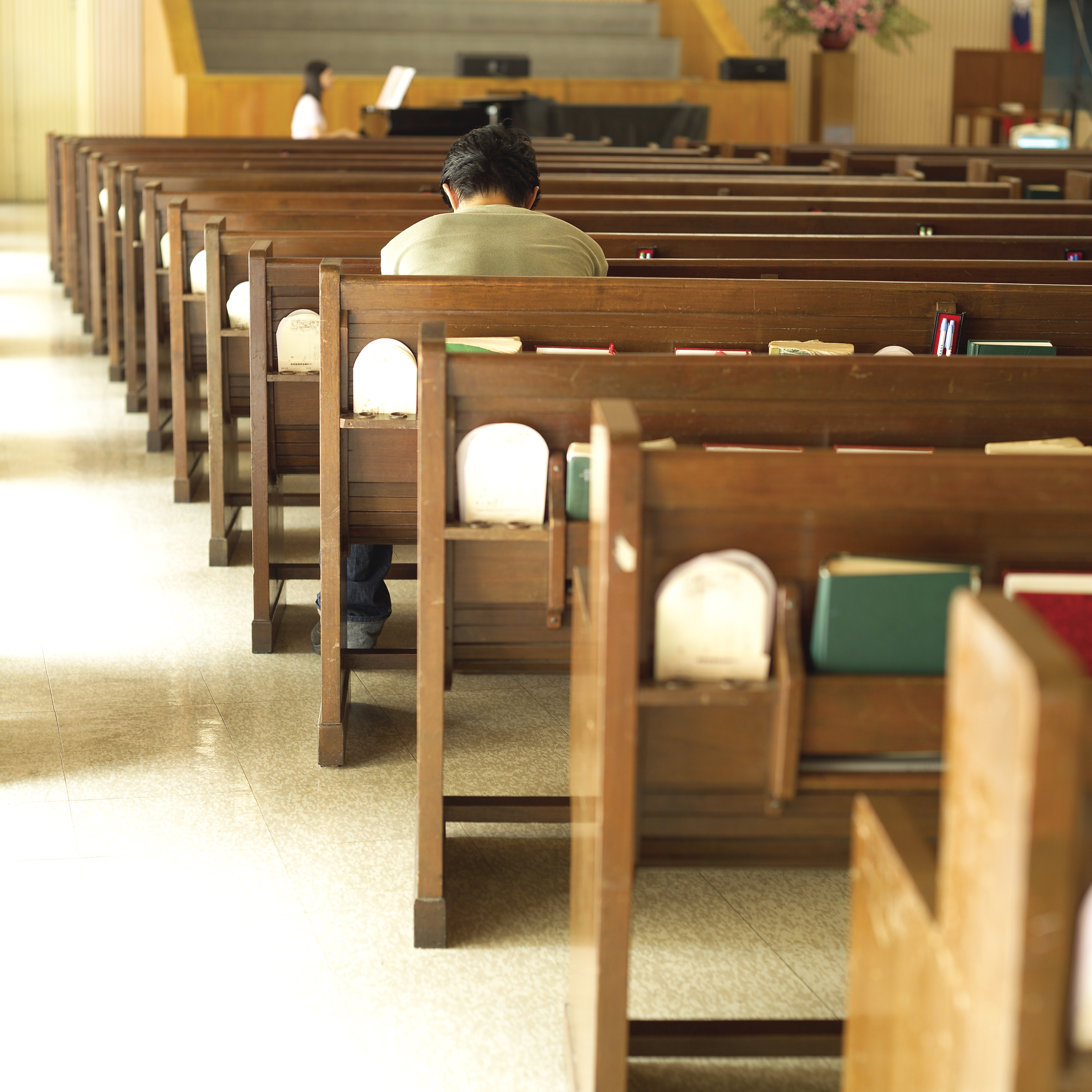 A man prays in an empty church.