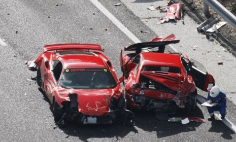 Two cars on the side of a Japanese highway after more than a dozen luxury cars, including 8 Ferraris and 1 Lamborghini, crashed on Sunday.