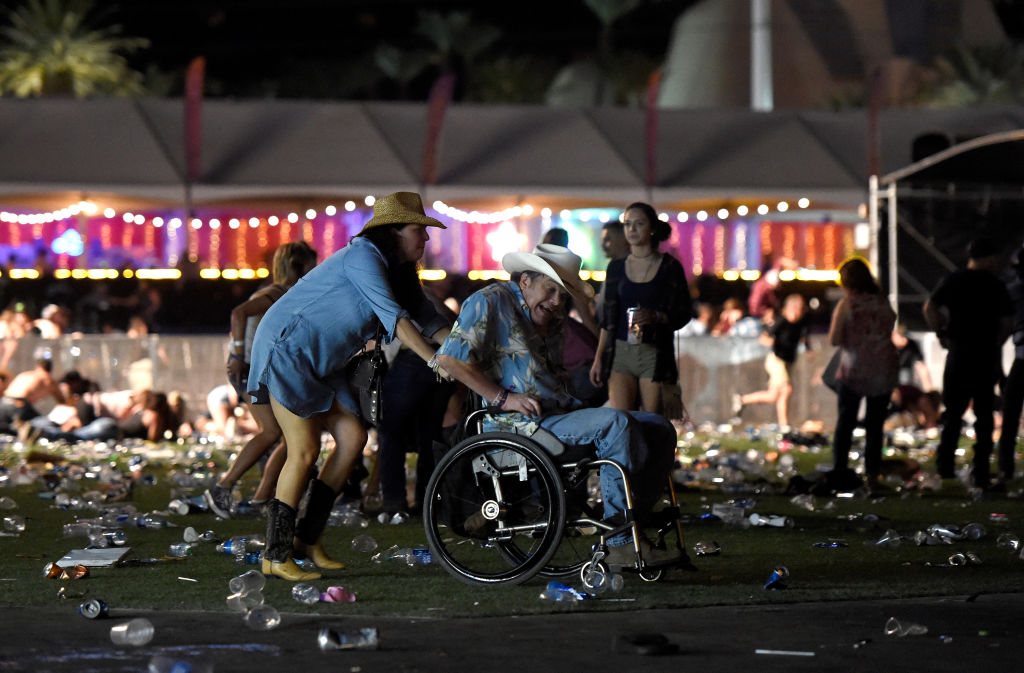 Concertgoers help disabled man on wheelchair at scene of shooting in Las Vegas. 