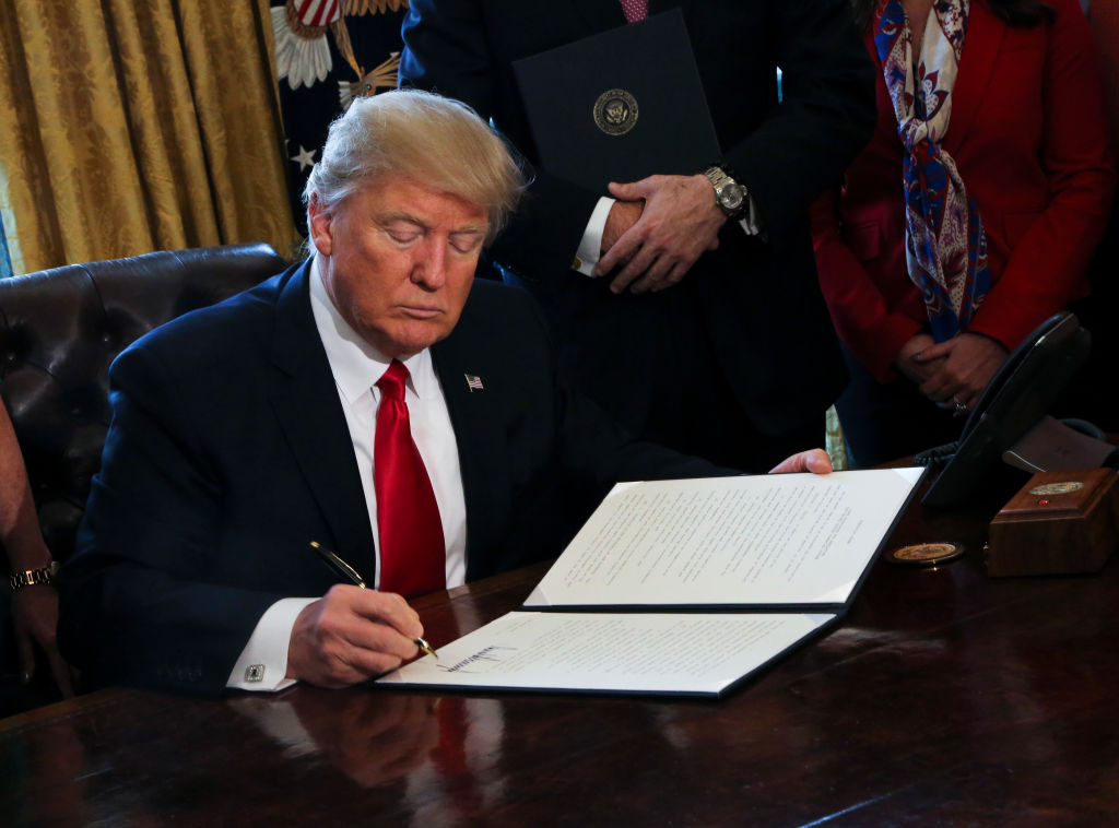 President Trump signing document.