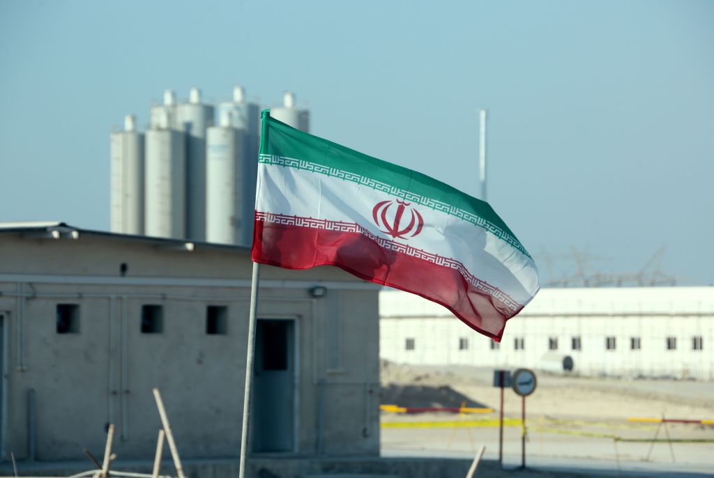 An Iranian flag in front of a nuclear facility.