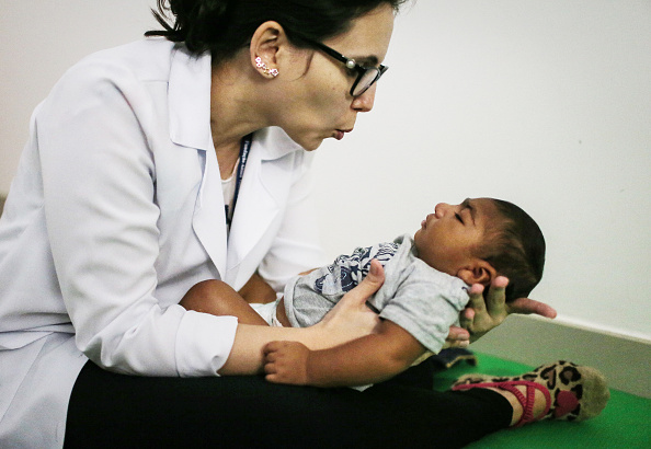 A doctor in Brazil holds a baby with microcephaly.