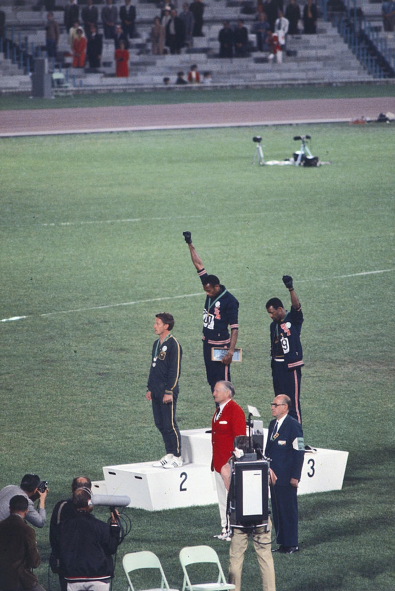 Olympic medalists Tommie Smith (center) and John Carlos (right) raise their fists during the national anthem in 1968.