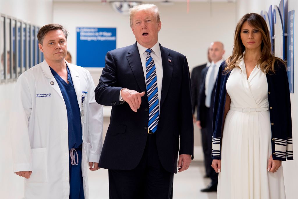 President Donald Trump speaks with doctor Igor Nichiporenko (L) and First Lady Melania Trump while visiting first responders at Broward Health North hospital Pompano Beach, Florida, on Februa