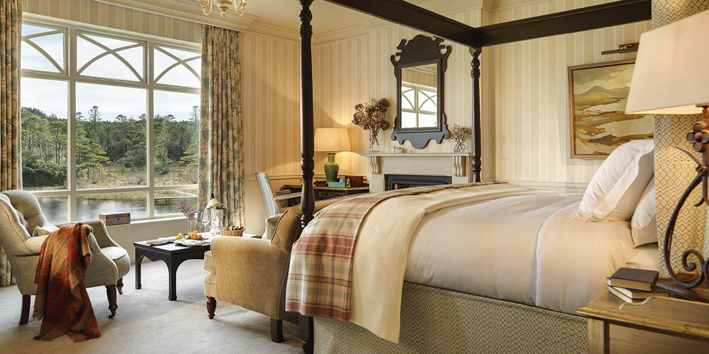 A bedroom with a river view at Ballynahinch Castle.