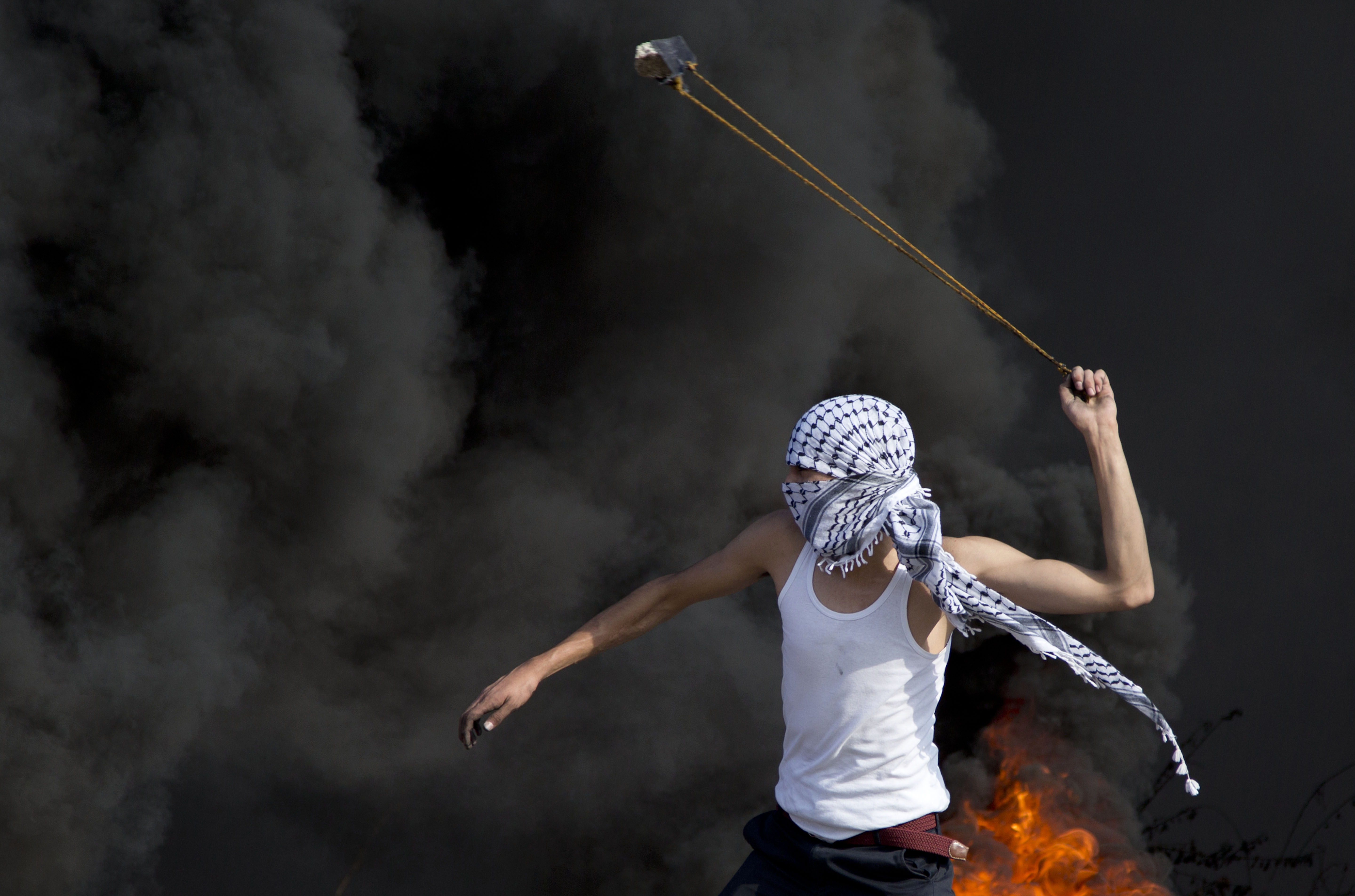 A Palestinian swings a sling during clashes with Israeli troops.