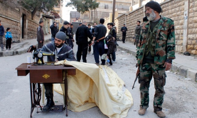 A Free Syrian Army fighter sews in the streets of Aleppo on Feb. 24