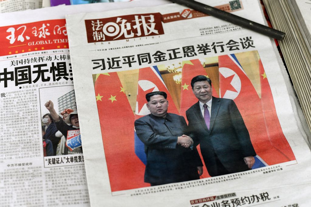 A newspaper shows Kim Jong Un and Xi Jinping.