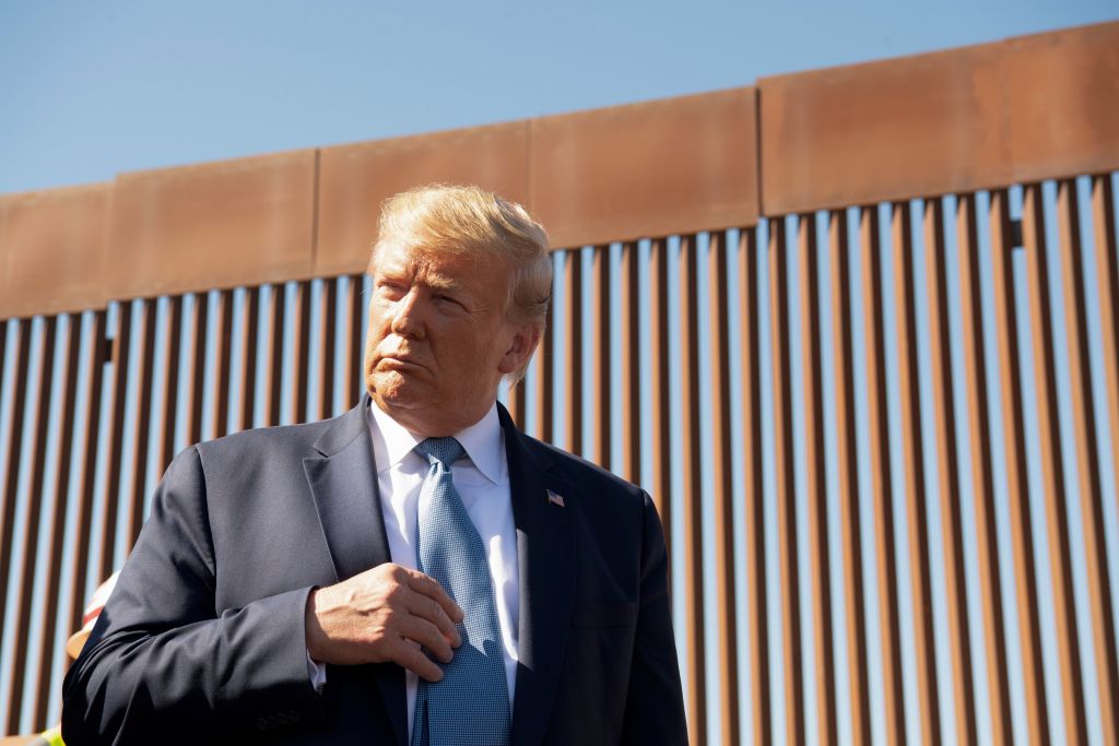 Donald Trump next to the border wall.