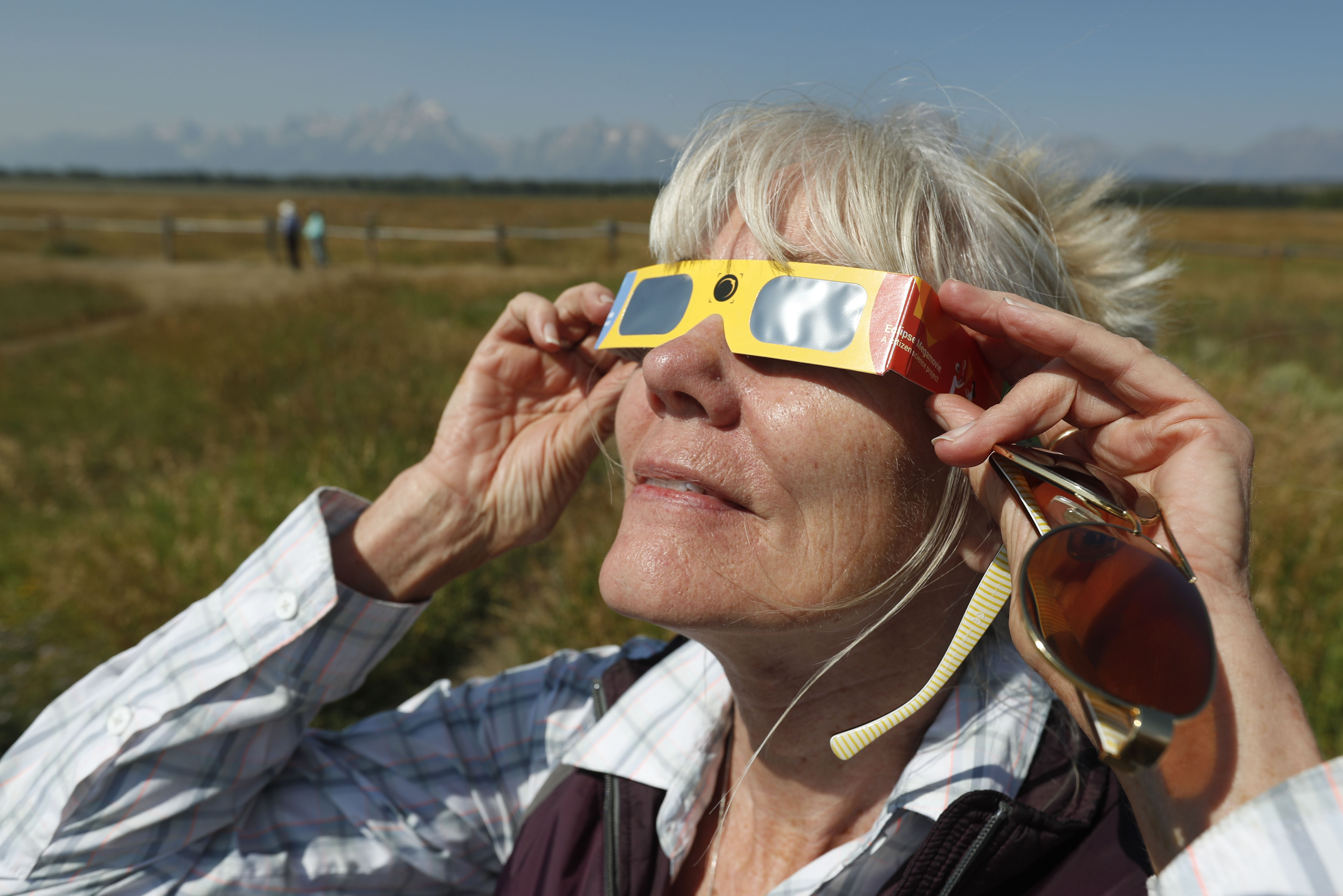 A woman tests her solar eclipse glasses