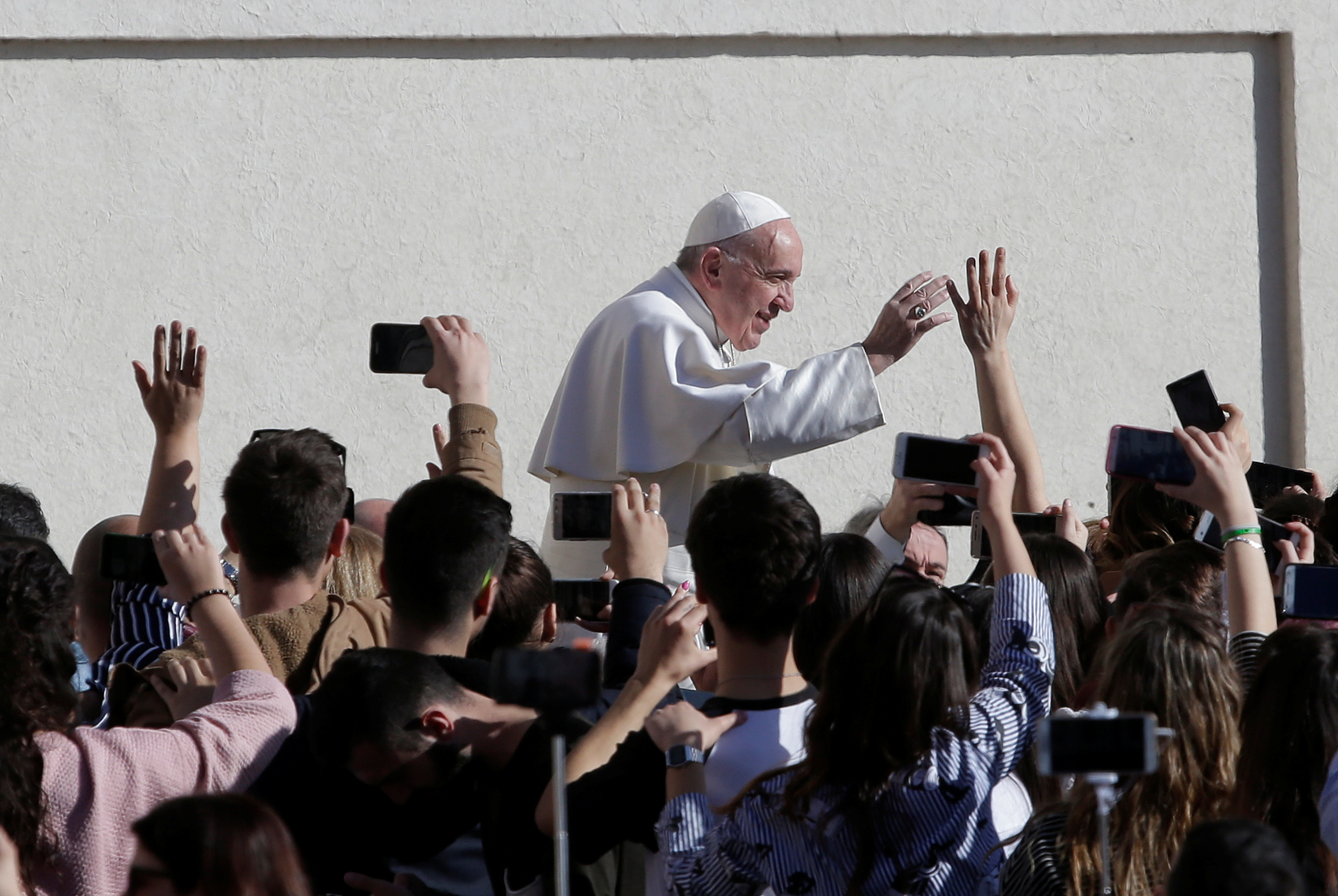 Pope Francis waves to onlookers while arriving at the Vatican.