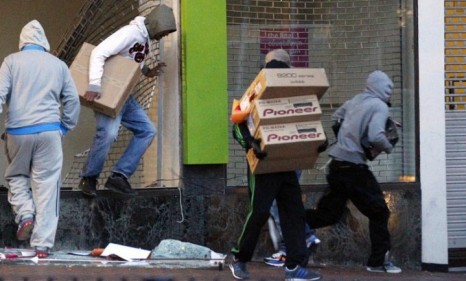 Looters carry boxes out of an electronic store during the London riots last week