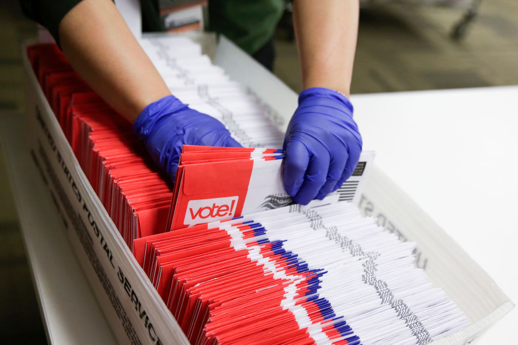 An election worker sorts mail-in ballots.