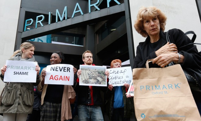 A shopper passes demonstrators outside clothing retailer Primark in central London on April 27.