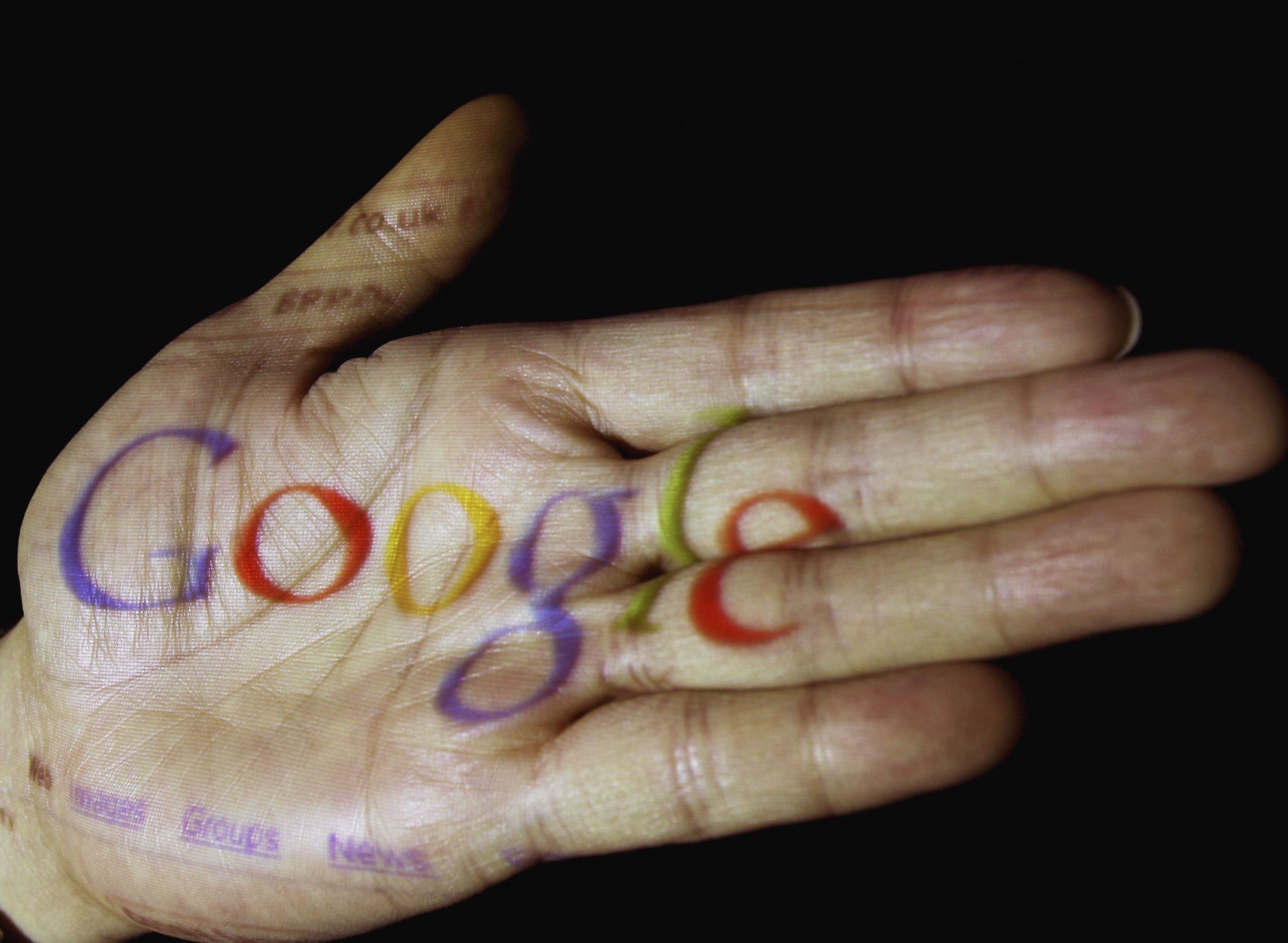 The Google logo on a hand