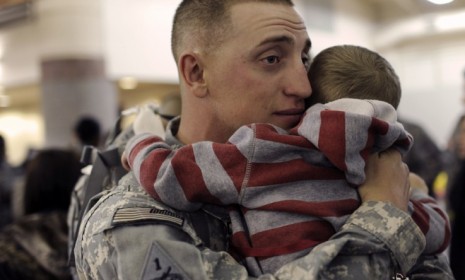 A soldier hugs his child during a homecoming ceremony at Fort Bliss, Texas: Because of familial strains or trauma of war, soldiers say it is harder coming home than leave.