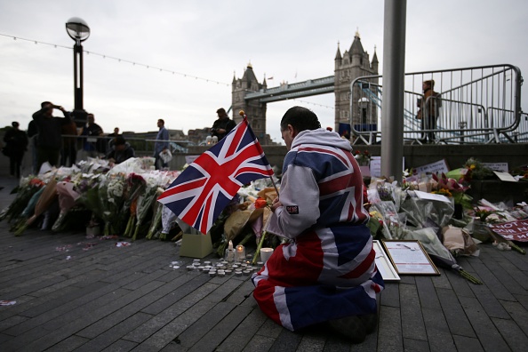 A man leaves items at a memorial for the victims of the London attack.
