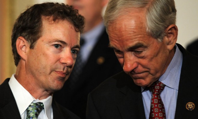 Sen. Rand Paul talks to his father then-Rep. Ron Paul during a news conference in 2011 in Washington.