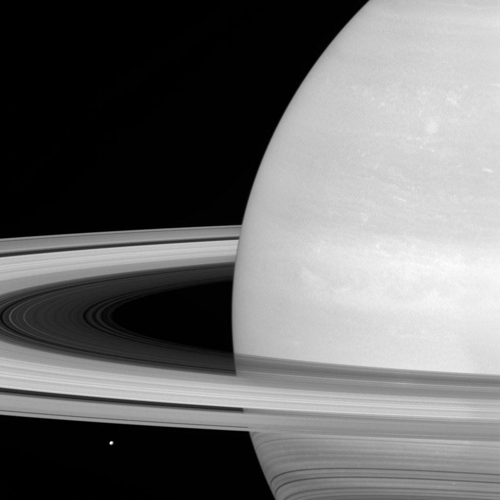 Saturn&#039;s moon Mimas is spotted near its rings.