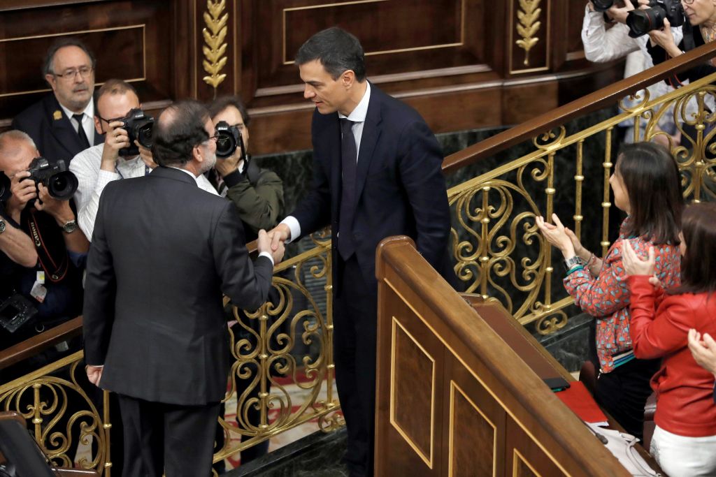 Outgoing Spanish Prime Minister Mariano Rajoy shakes hands with successor Pedro Sanchez