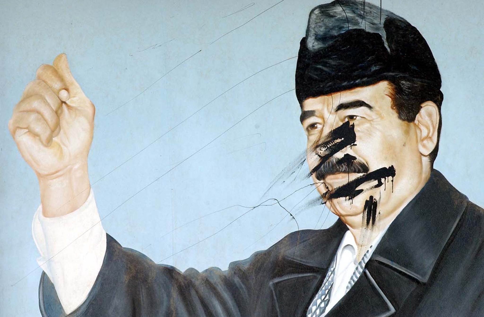 A defaced mural of Saddam Hussein.