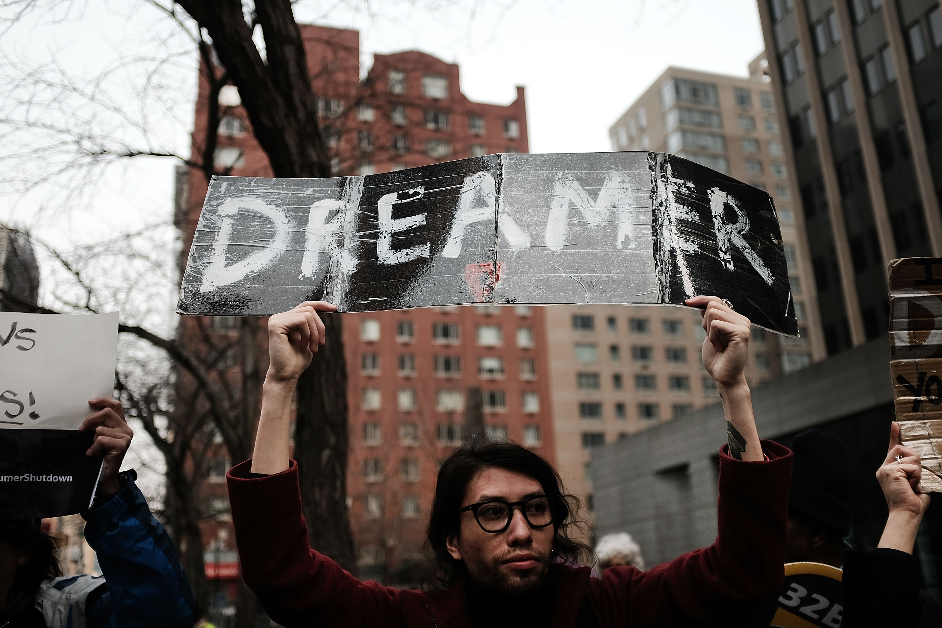 A man holds a DREAMer sign