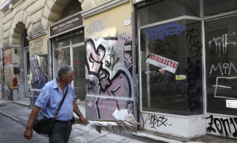 A man walks past a shuttered store in Athens, Greece: The financially strapped country is trying to secure an $11 billion bailout to avoid defaulting on its massive debt.