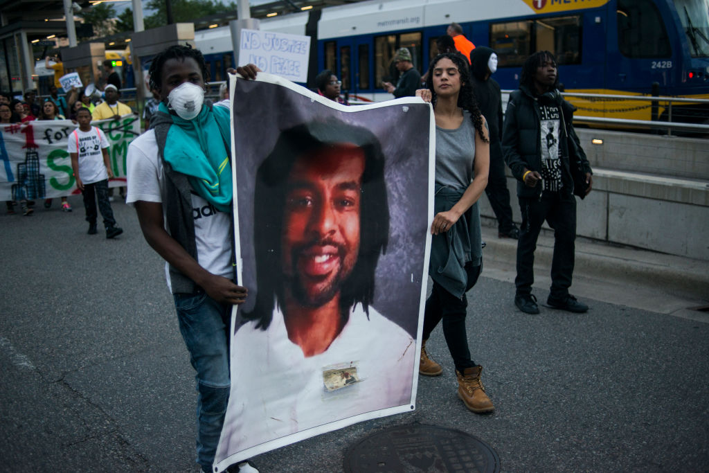 Demonstrators carry a photo of Philando Castile.