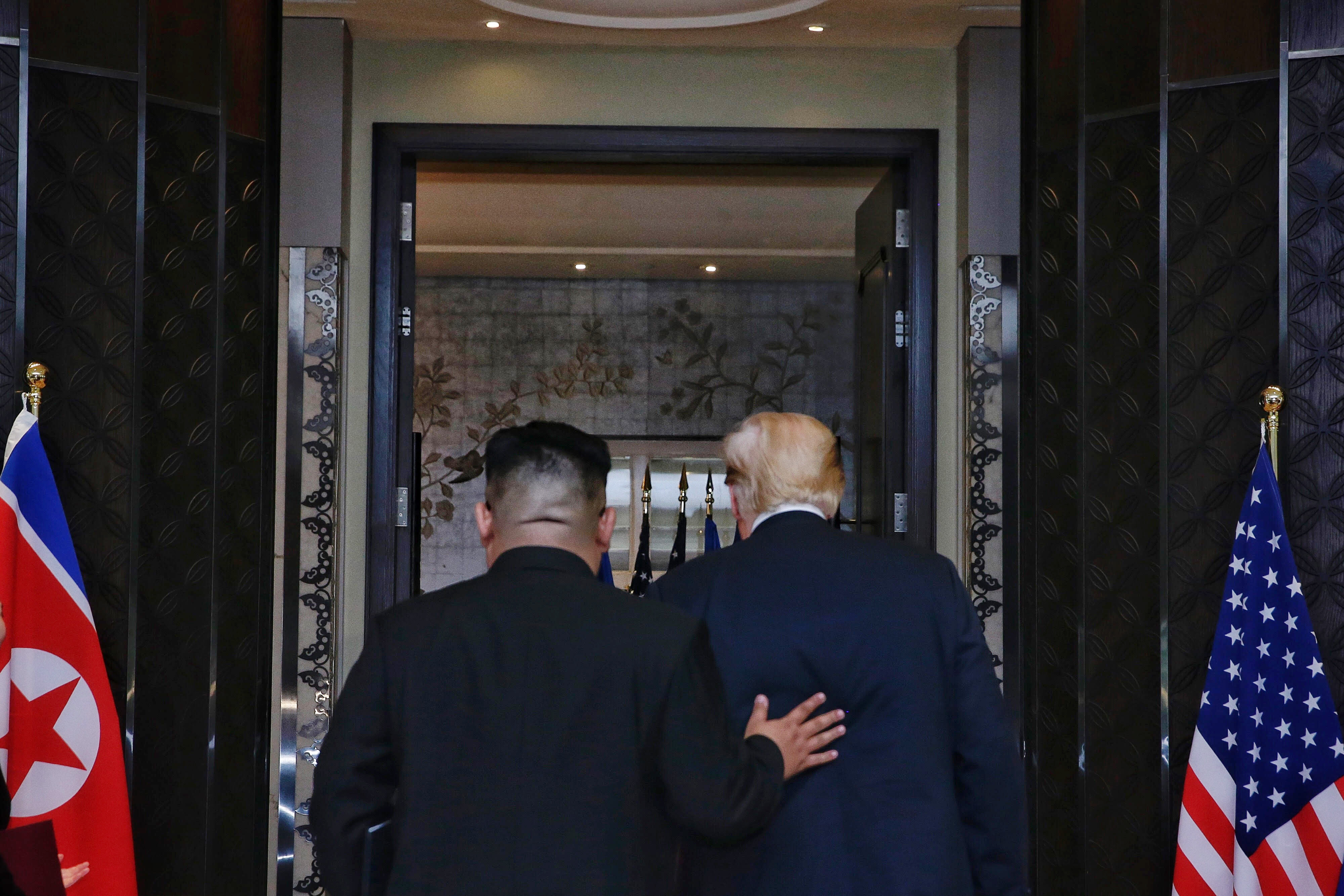 Kim places his hand on Trump&#039;s back