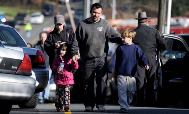Parents leave a staging area after being reunited with their children following the shooting in Newtown, Conn.