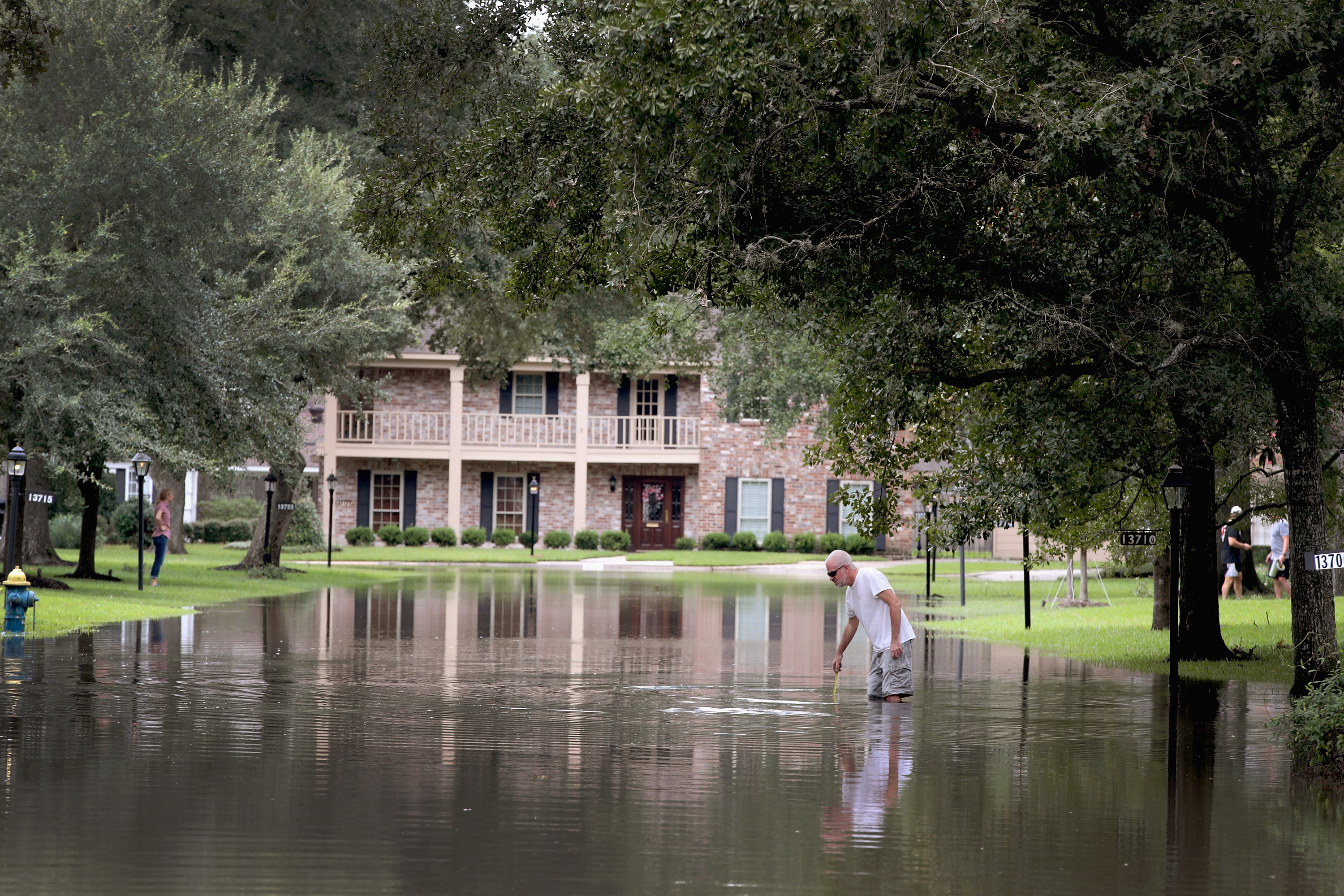 A Houston man measures the flood waters.