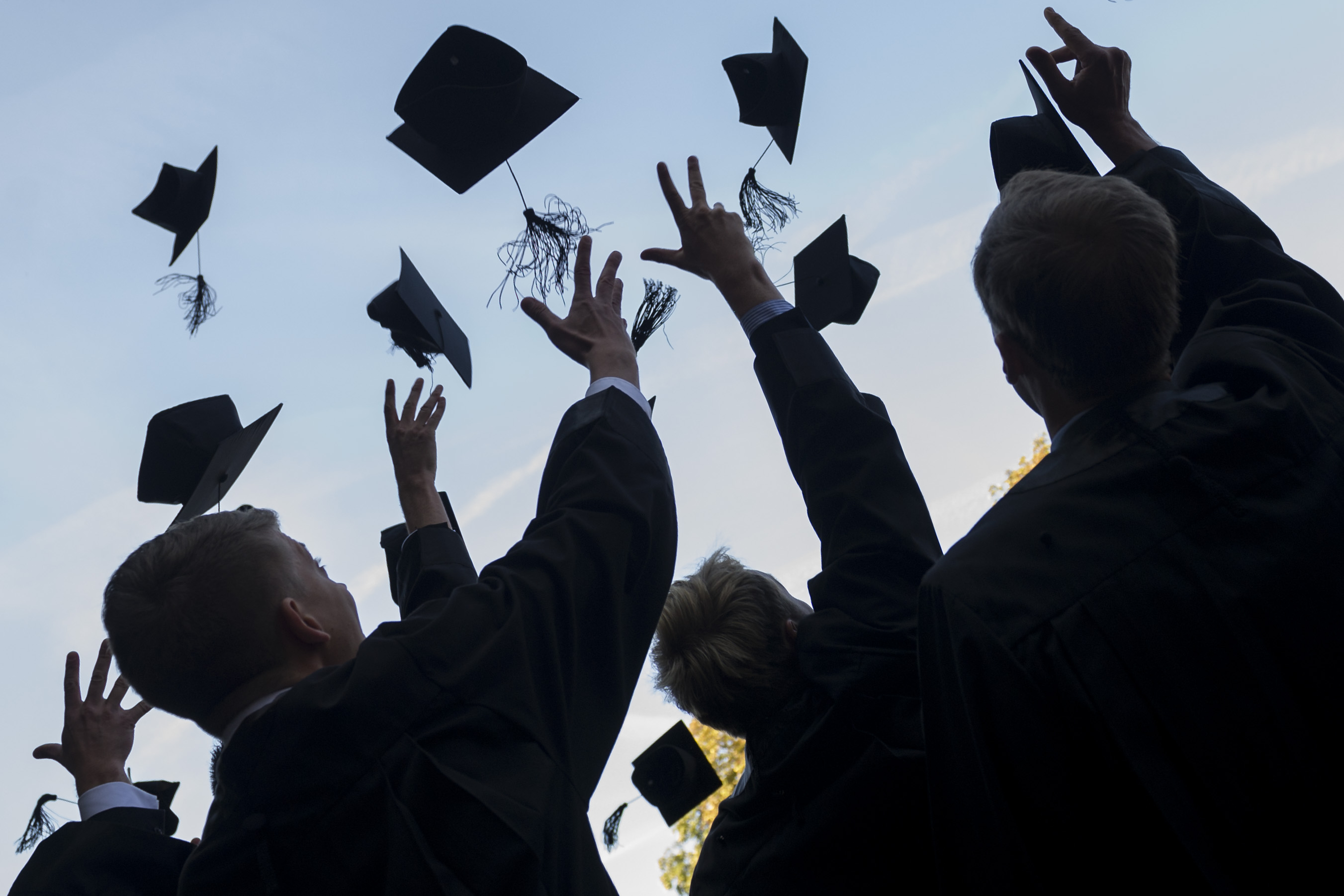 Graduates throw their caps in the air.