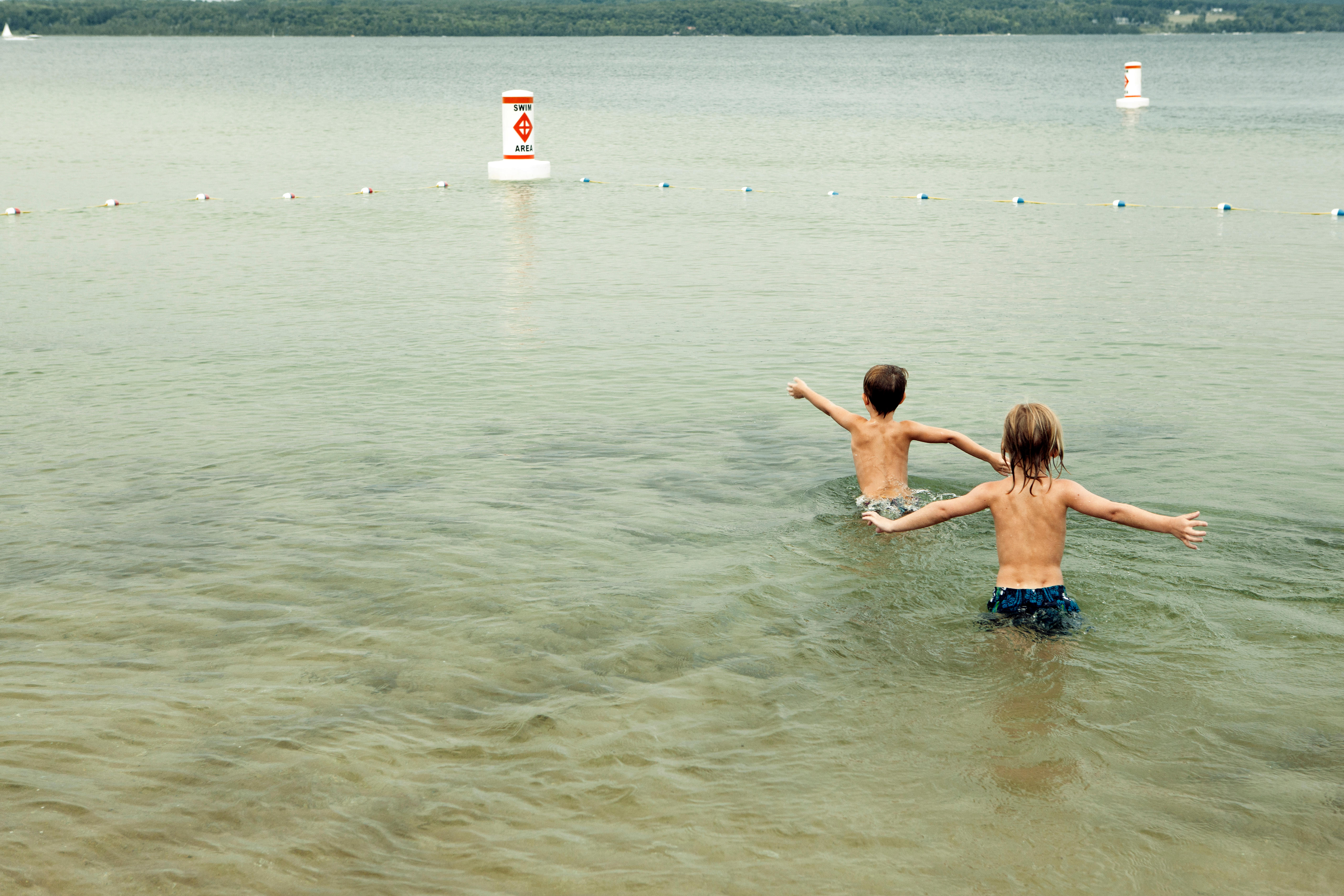 Boys swimming in a lake.