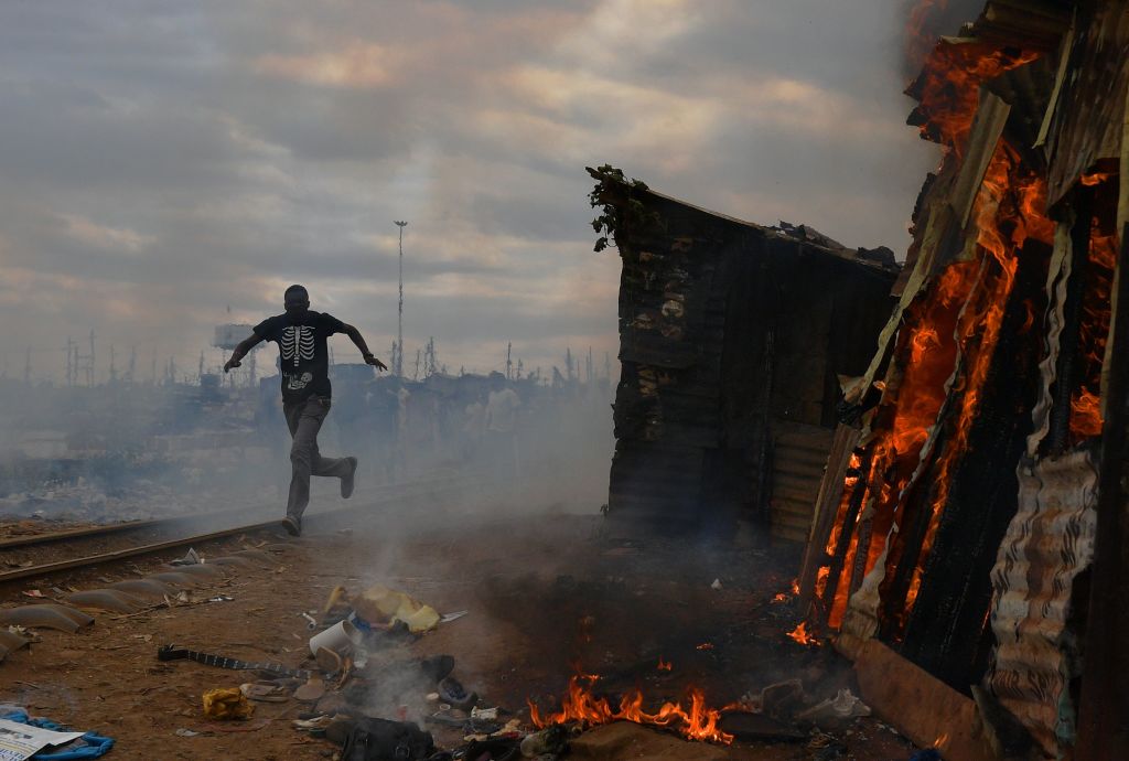 A man runs past a burning shack in Kenya