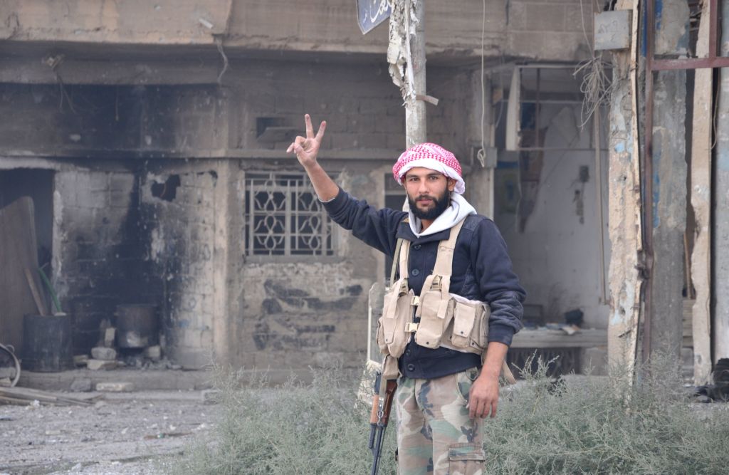 Syrian pro-government militant flashes a victory sign