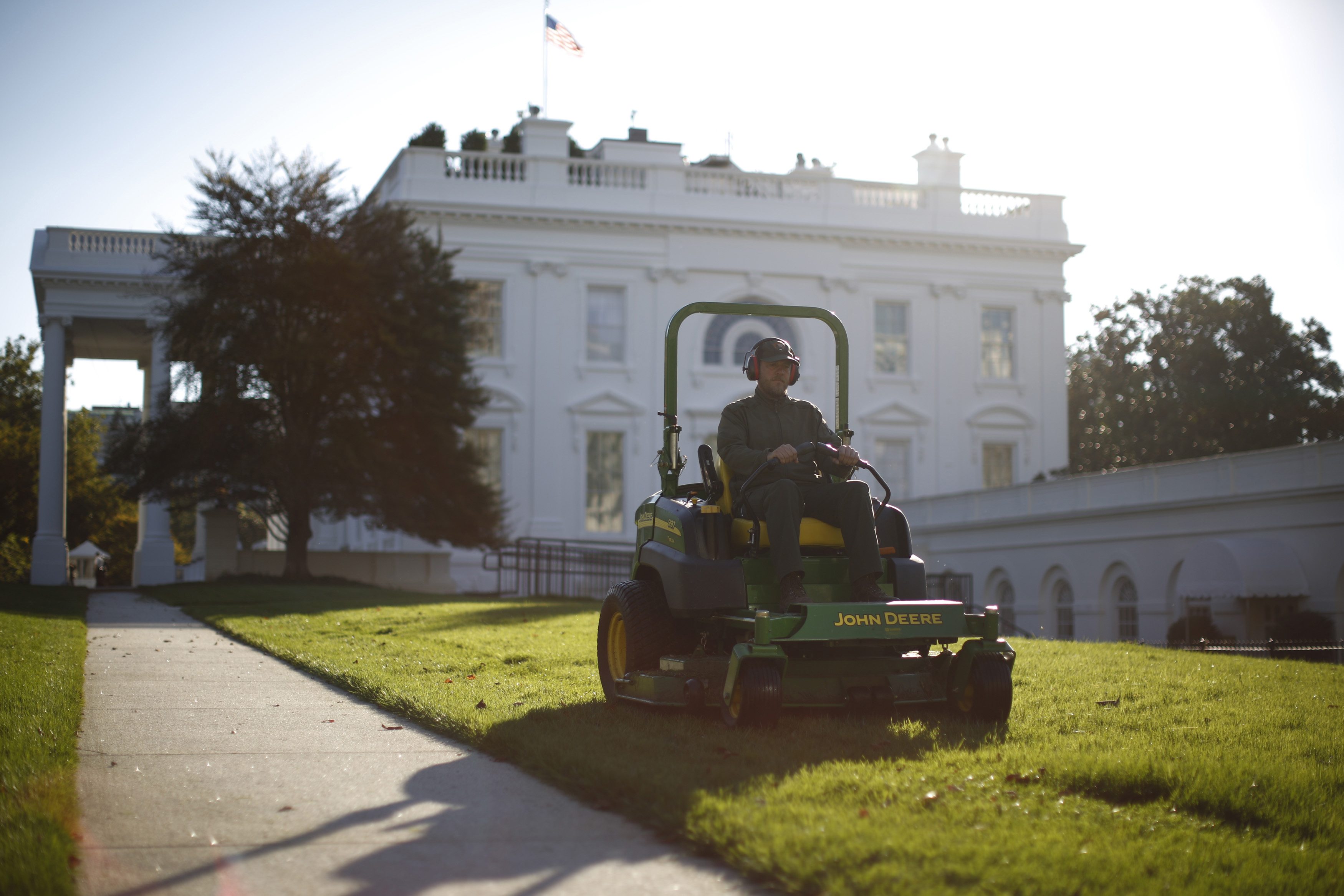 A National Parks Service employee mows the White House lawn.