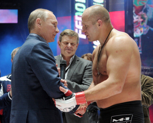 Vladimir Putin (L) shakes hands with Mixed Martial Art (MMA) heavyweight fighter Fedor Emelianenko of Russia in 2011