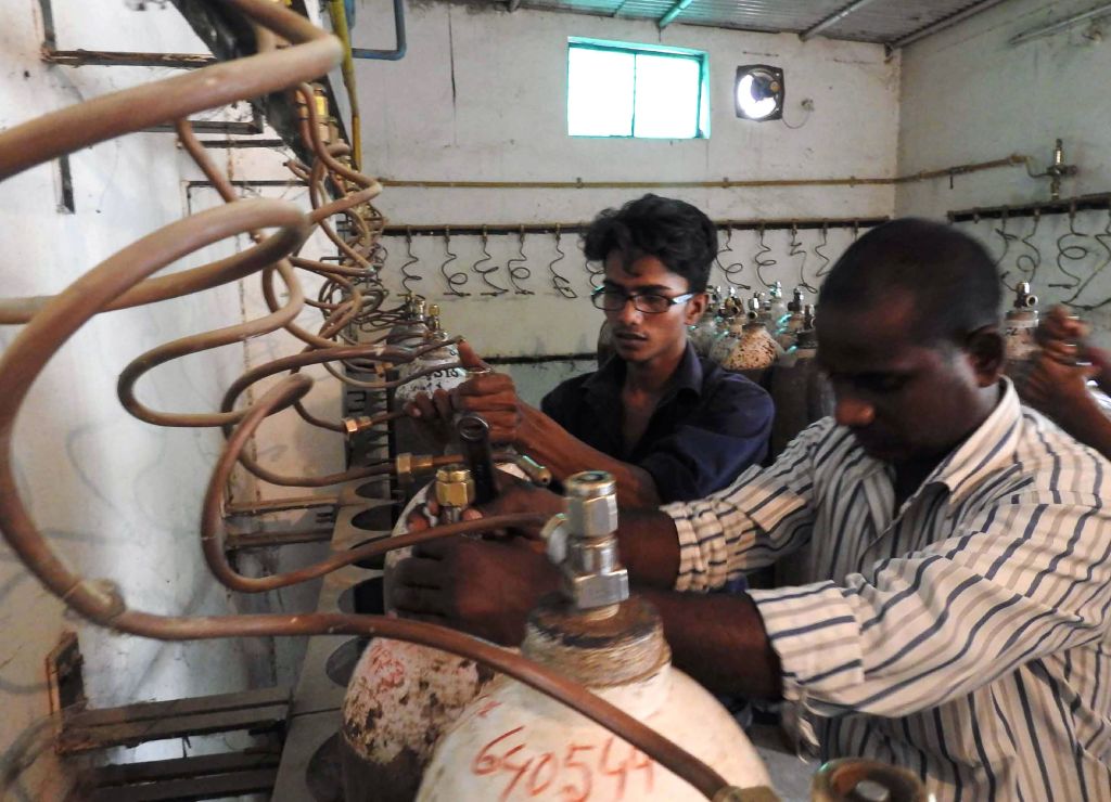 Indian workers examine oxygen cylinders at the Baba Raghav Das Hospital in Gorakhpur, in the northern Indian state of Uttar Pradesh, on August 12, 2017.