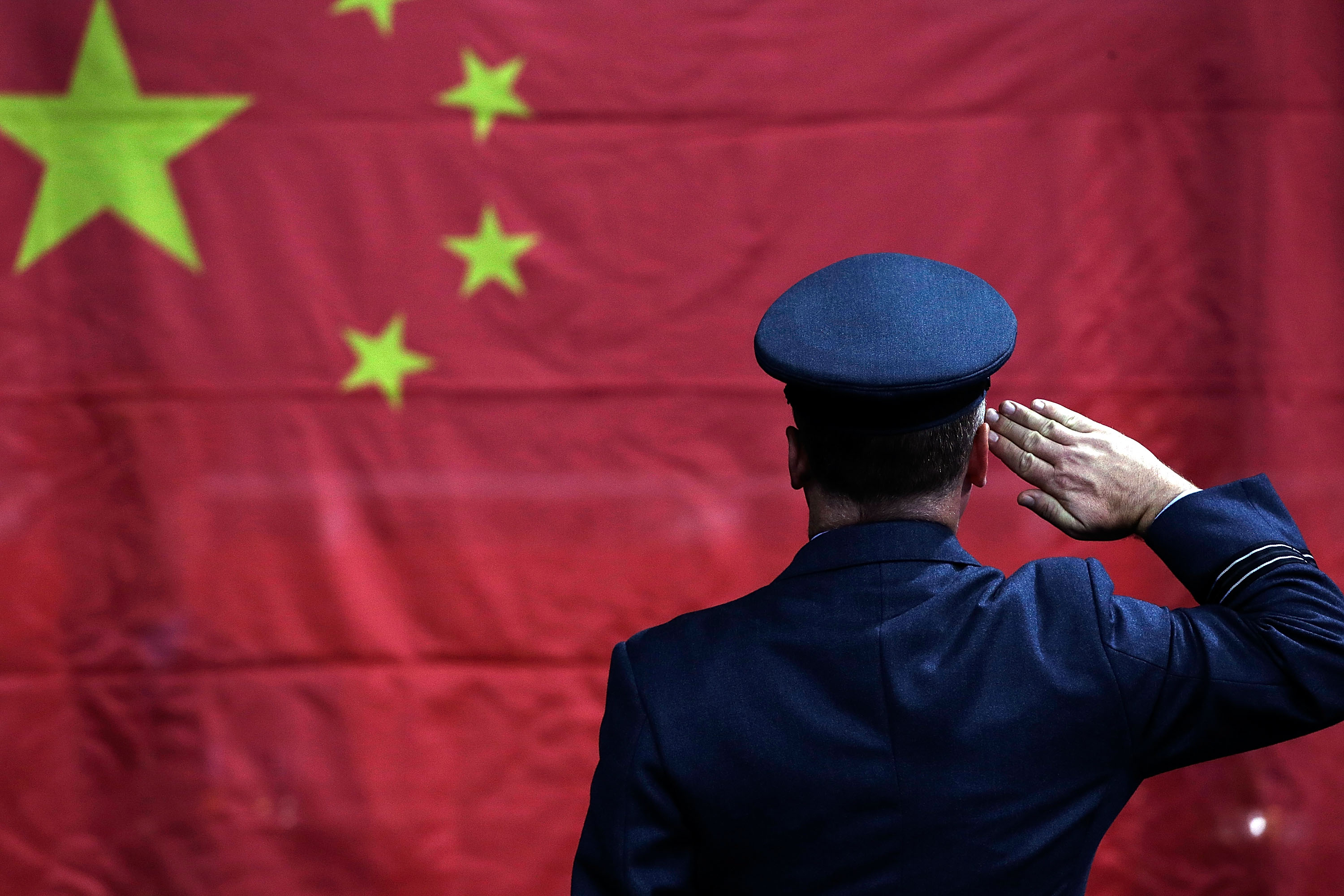 A Chinese soldier salutes his flag