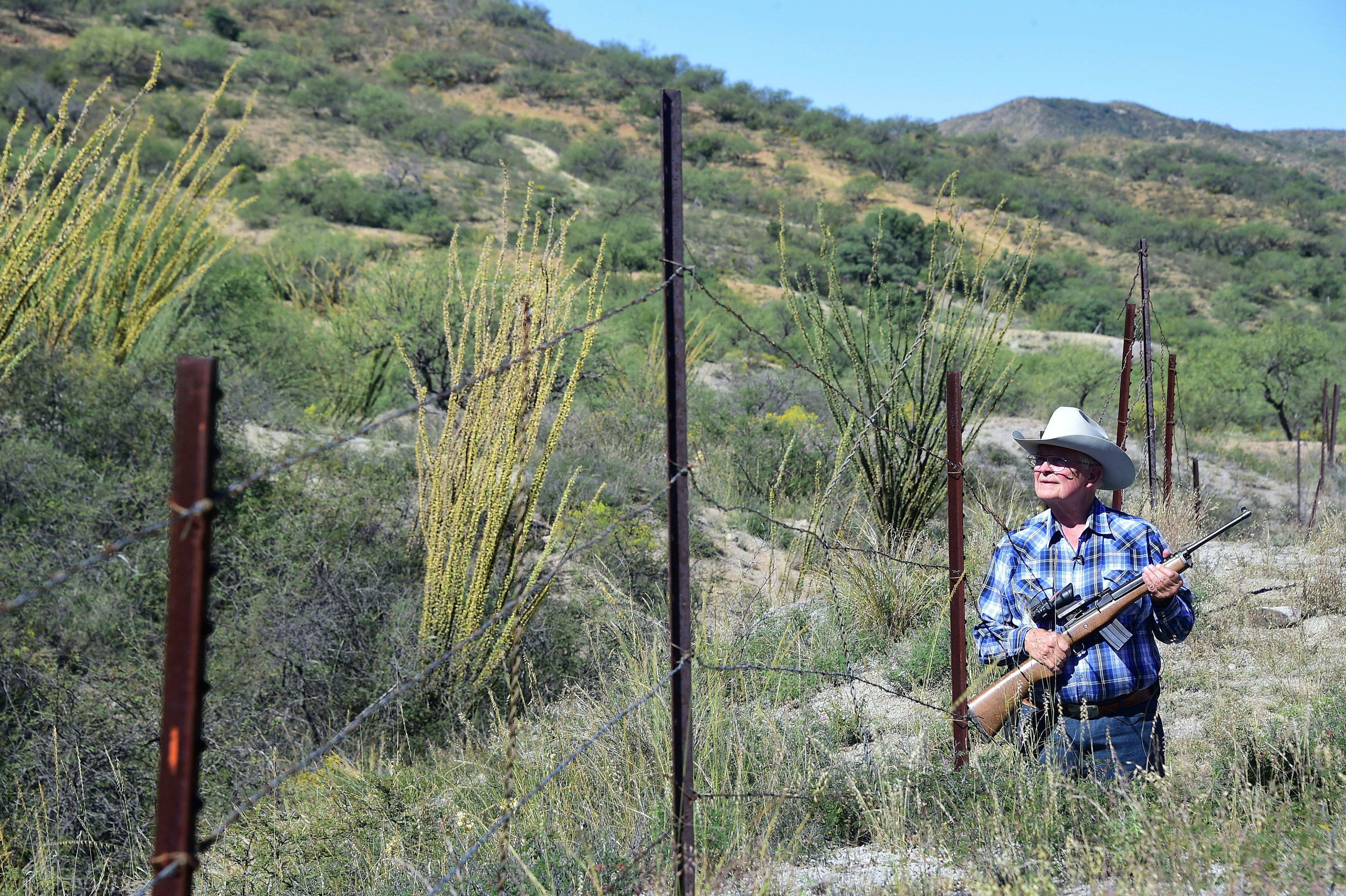 Jim Chilton walks beside a border fence on his ranch in Arivaca, Arizona.