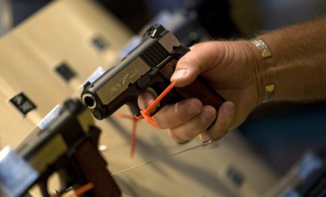 A man grips a gun at last year&#039;s National Rifle Association meeting.