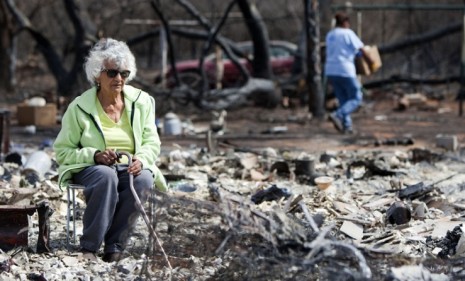 A woman sits in what used to be her bedroom after wildfires ripped through Colorado City, Texas in March.