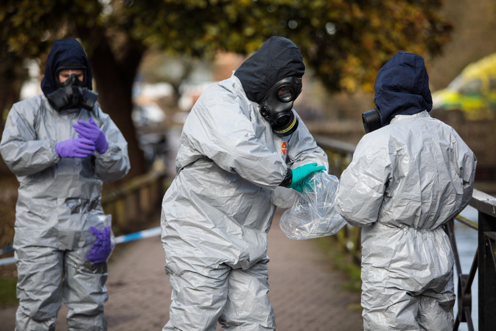 Police officers in protective suits working at scene of poisoning in UK.