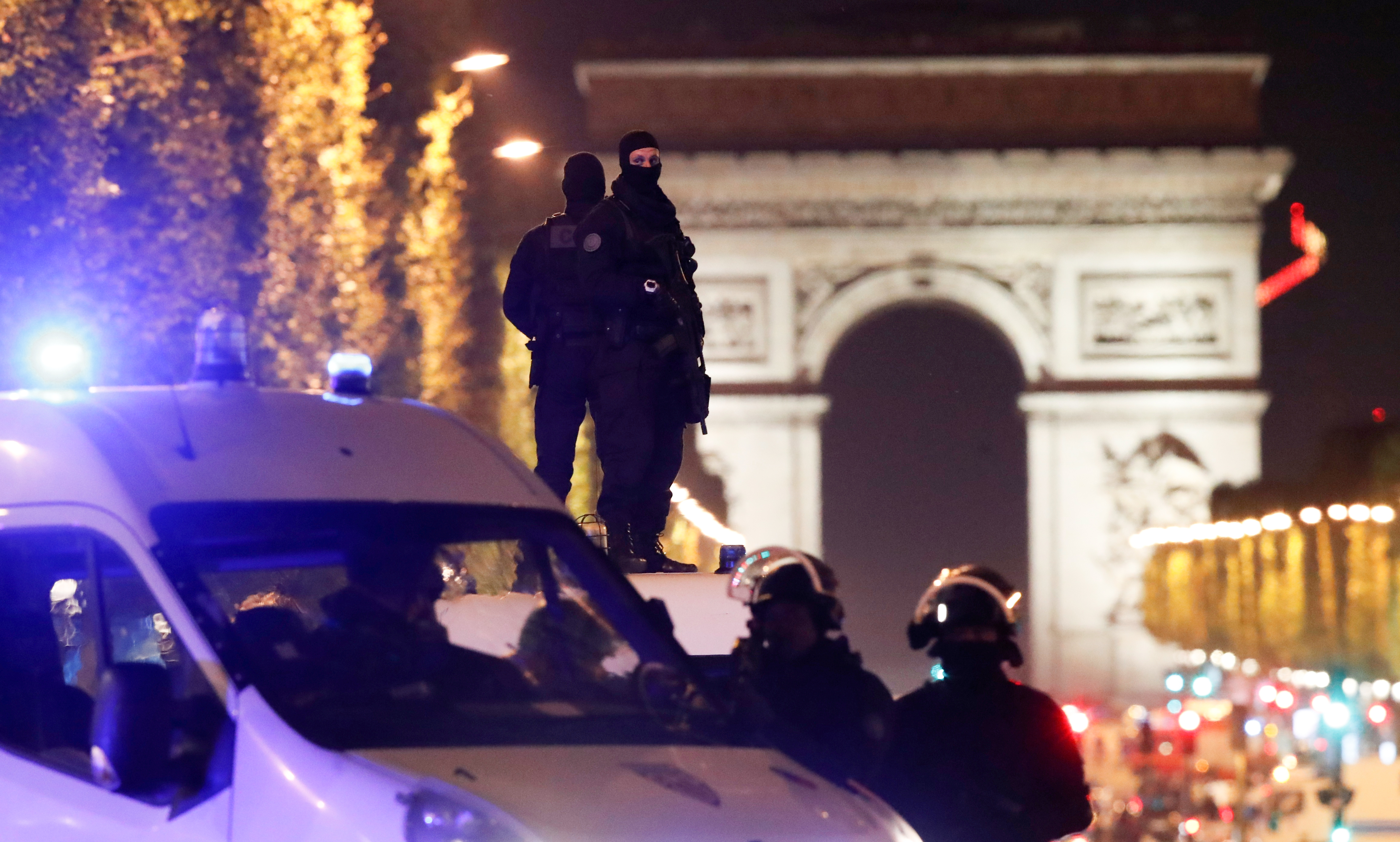 Masked gunman guard the Champs Elysees Avenue after a gunman opened fire.