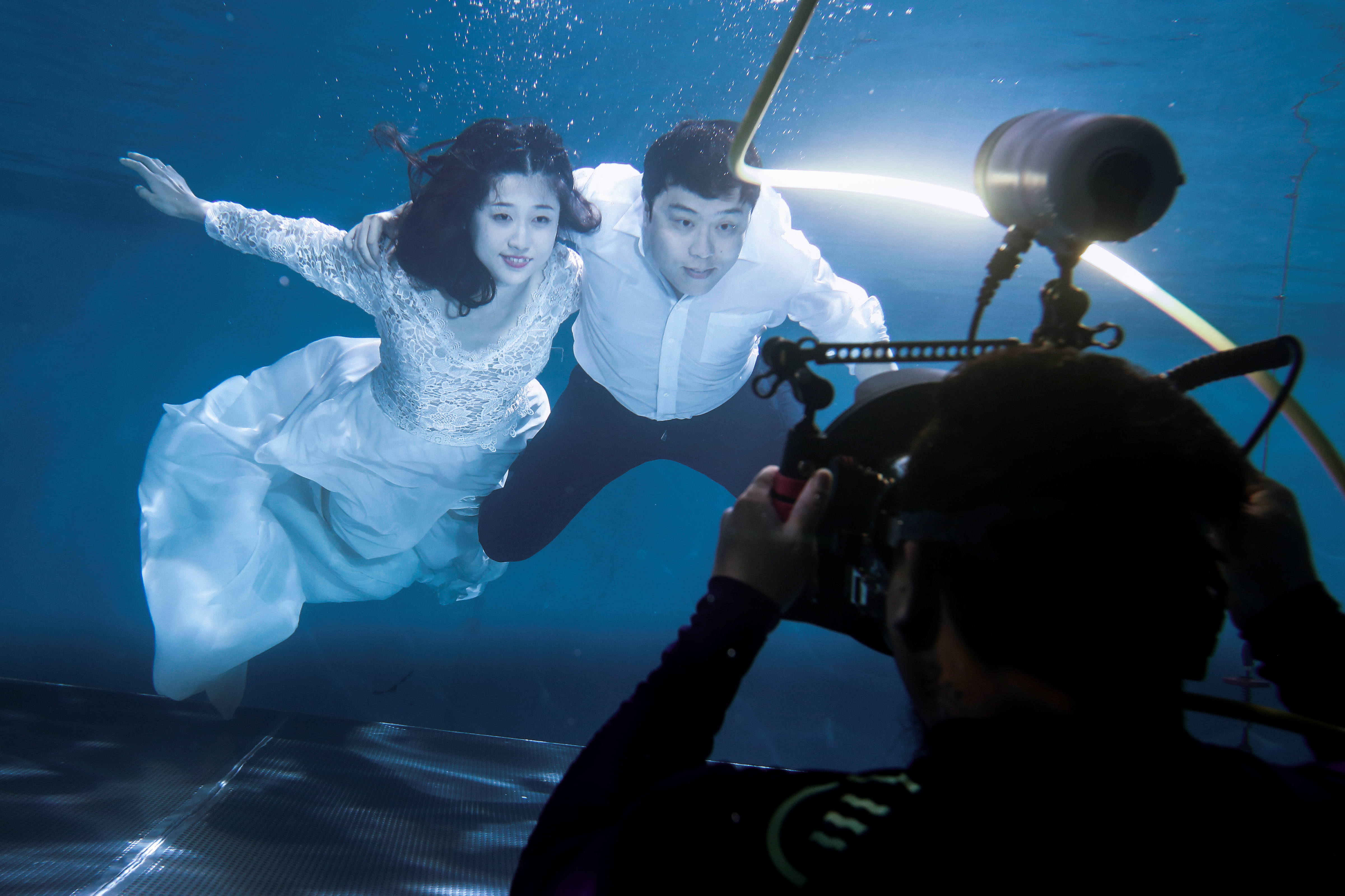 A newly married couple has their wedding photos taken underwater in Beijing.